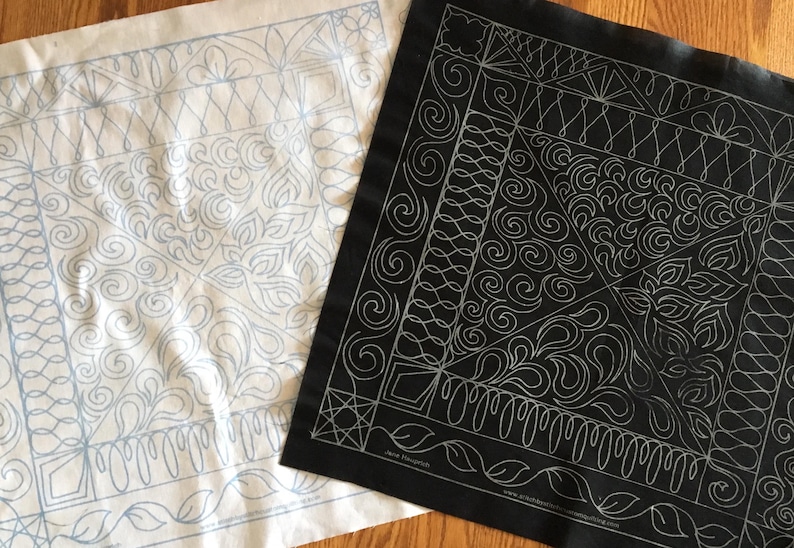 May include: Two pieces of fabric with a white background and black background. Both fabrics have a pattern of swirls and lines in a light blue color on the white fabric and a silver color on the black fabric.