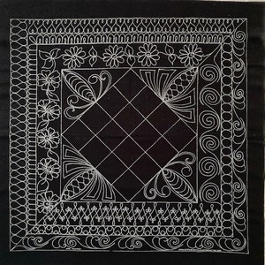 May include: Black fabric with a white design of a diamond shape with a decorative border. The border features floral designs, swirls, and geometric patterns.