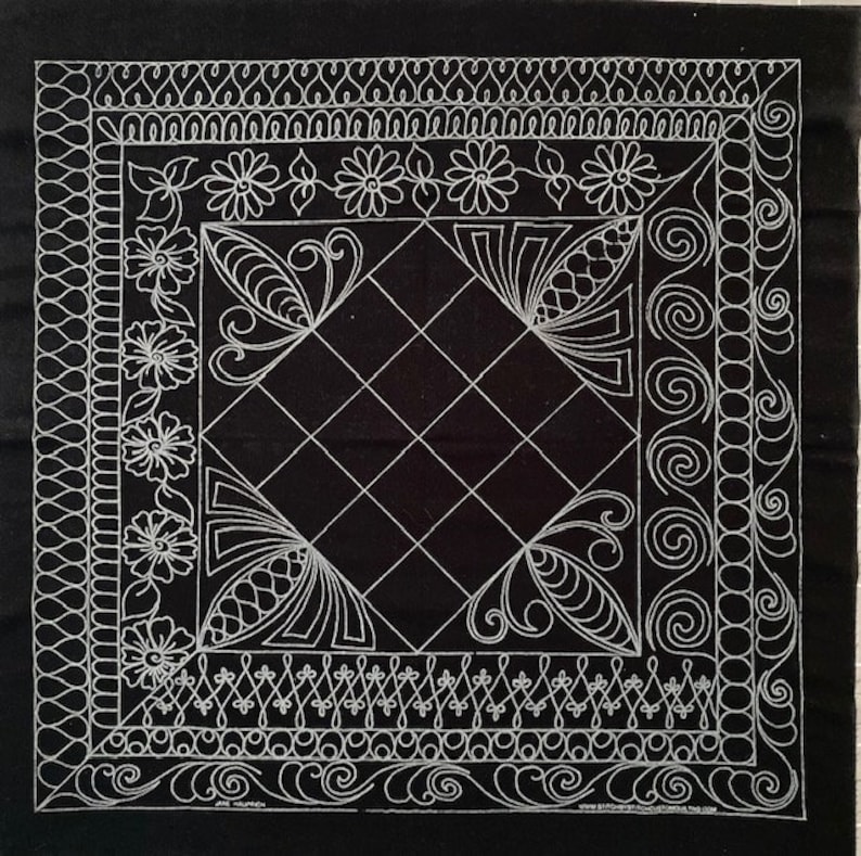 May include: Black fabric with a white design of a diamond shape with a decorative border. The border features floral designs, swirls, and geometric patterns.