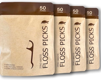 Może przedstawiać: Cztery brązowe saszetki, każda z 50 kompostowalnymi wykałaczkami do nici dentystycznej. Saszetki są oznaczone jako "Zero Waste Floss Picks" i mają logo żółwia. Tekst "50 Flossers" jest nadrukowany na górze każdej saszetki. Saszetki są wykonane z brązowego papieru i mają białe tło.