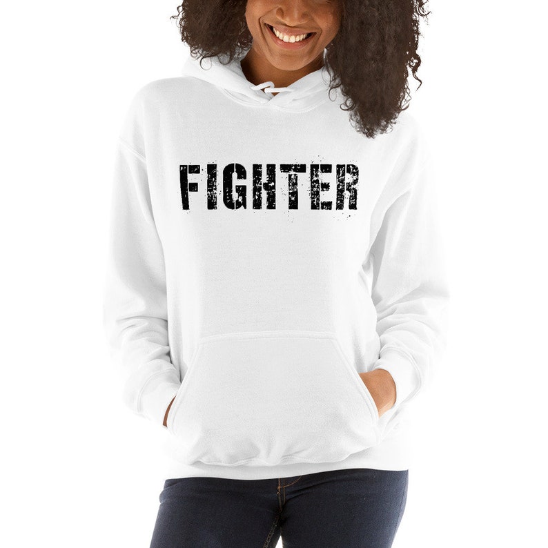 May include: White hooded sweatshirt with the word "FIGHTER" printed in black on the front.