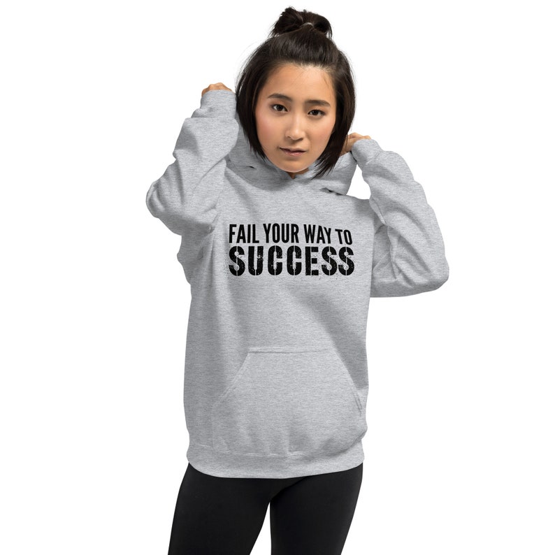 May include: A grey hooded sweatshirt with the text "Fail your way to success" printed in black.