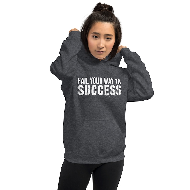 May include: A dark grey hooded sweatshirt with the text "Fail your way to success" printed in white on the front.