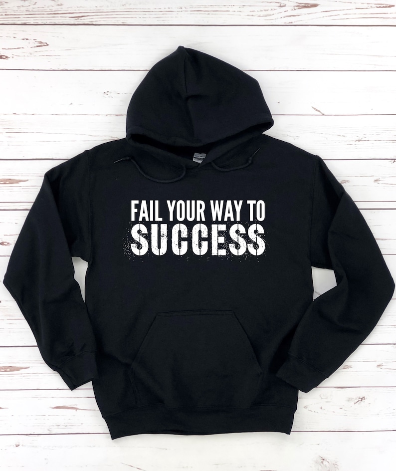 May include: Black hooded sweatshirt with the text "Fail your way to success" in white lettering with a distressed effect.