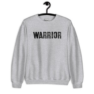 Puede incluir: Una sudadera gris con la palabra "WARRIOR" impresa en negro en la parte delantera.