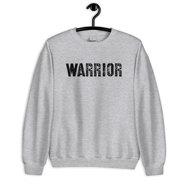 Puede incluir: Una sudadera gris con la palabra "WARRIOR" impresa en negro en la parte delantera.