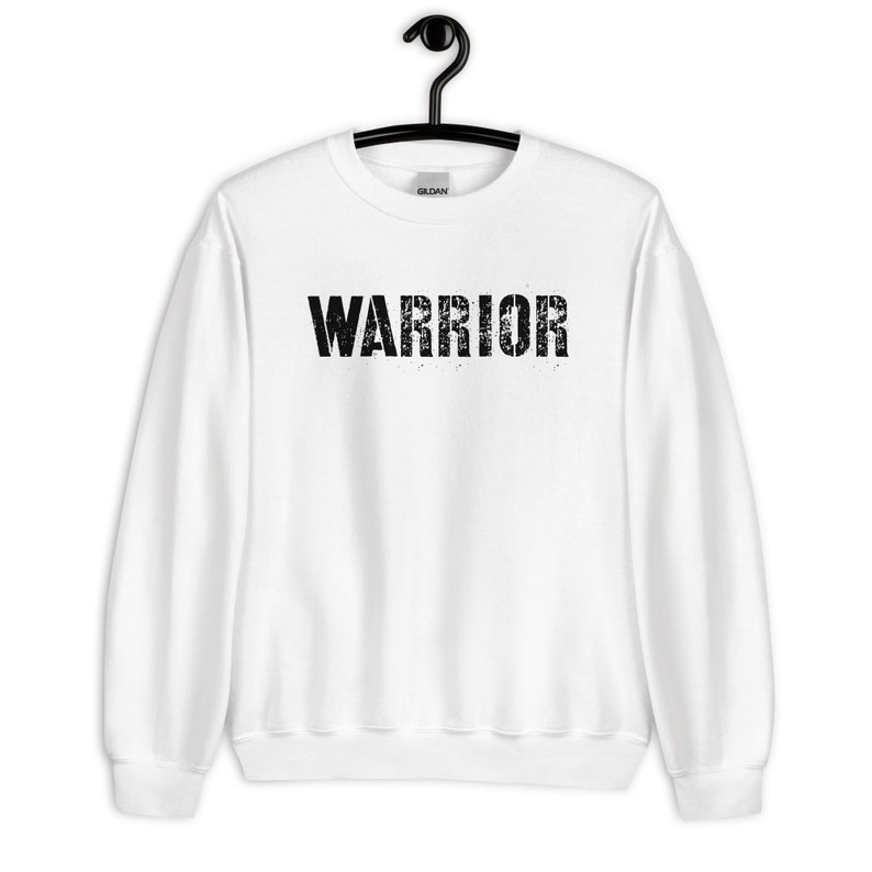 Puede incluir: Sudadera blanca con un gr&aacute;fico negro desgastado que dice "WARRIOR".