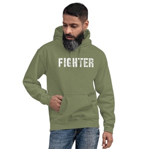 May include: A green hooded sweatshirt with the word "FIGHTER" printed in white on the front.