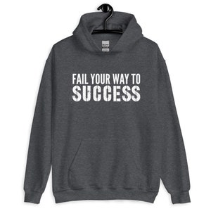 May include: A dark grey hooded sweatshirt with the text "Fail your way to success" printed in white on the front.