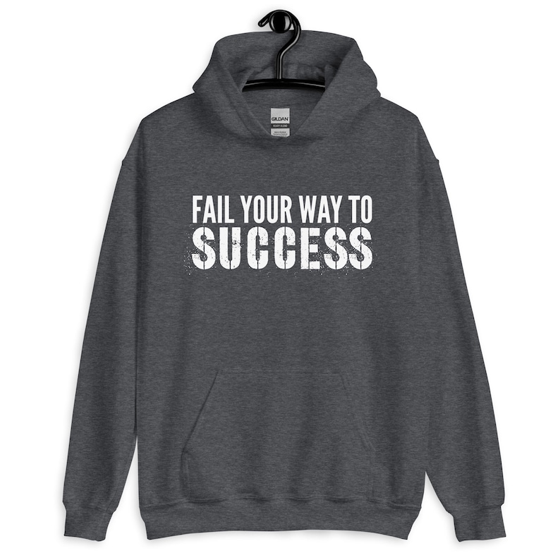 May include: A dark grey hooded sweatshirt with the text "Fail your way to success" printed in white on the front.