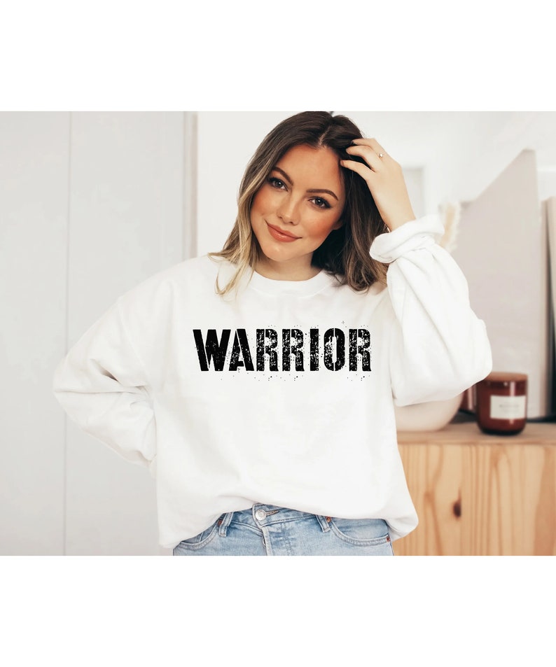 Puede incluir: Sudadera blanca con la palabra "WARRIOR" impresa en negro en la parte delantera.