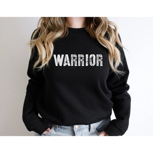 Puede incluir: Sudadera negra con la palabra "WARRIOR" impresa en blanco en la parte delantera.