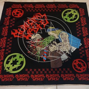 May include: Black square bandana with a graphic illustration of a violent scene. The design features a figure with tattoos, a zombie, and the words "Municipal Waste" in red. Green and red symbols are in the corners.