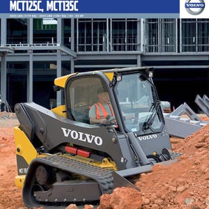 Op de afbeelding: Een gele en grijze Volvo compacte rupslader, model MCT125C, MCT135C, wordt getoond in een buitenomgeving. De machine staat op een hoop roodbruine aarde. De tekst "VOLVO" is prominent aanwezig.
