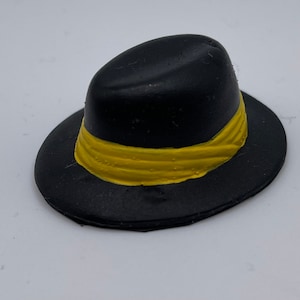 May include: A black fedora hat with a yellow band around the crown.