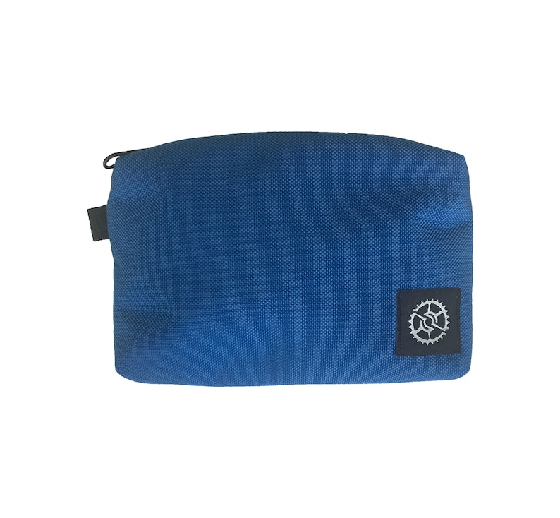 K&ouml;nnte beinhalten: Eine kleine, blaue Rei&szlig;verschlusstasche mit einem schwarzen Rei&szlig;verschluss und einem schwarzen Logo mit einem wei&szlig;en Zahnrad.