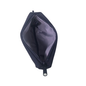 K&ouml;nnte beinhalten: Eine schwarze Rei&szlig;verschlusstasche mit grauem Futter. Die Tasche ist offen und der Rei&szlig;verschluss ist heruntergezogen.