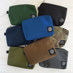 Small Pouch w Sprocket logo tag. 7 Colors. Water Resistant Nylon w/ Silver Nylon Lining. Made in USA. (Includes detachable black carabiner)