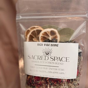 May include: A transparent bag containing a simmer pot potion blend. The label reads "SACRED SPACE" and "SIMMER POT POTION BLEND". The bag includes dried lemon slices, bay leaves, and a mix of herbs and botanicals.