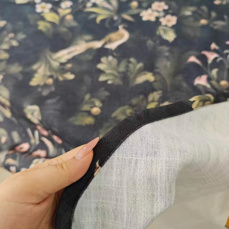 Close-up of the Dark Fern & Finch tablecloth showing its detailed botanical print with muted green foliage and delicate floral accents on a deep navy background. The image highlights the fabric texture, neatly finished edge, and carefully stitched hem, showcasing the craftsmanship and finishing details of this custom tablecloth.