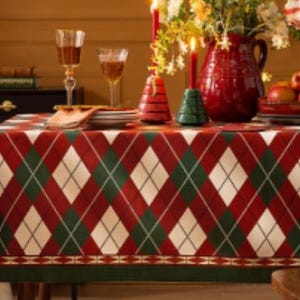 May include: Red, green, and white plaid tablecloth with a diamond pattern. The tablecloth has a border with a repeating pattern of small green and white triangles.