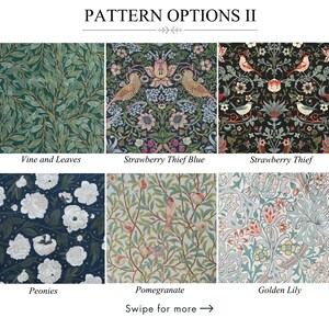 May include: A dark blue tablecloth with a floral pattern in shades of green, red, and beige. The tablecloth is draped over a wooden table, with a matching napkin and a white vase visible. The table is set with plates, bowls, and wine glasses.