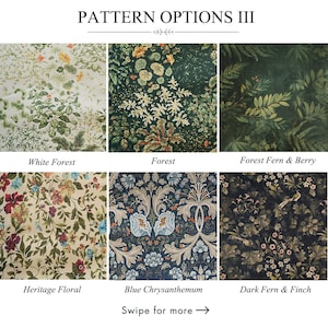 May include: A dark blue tablecloth with a floral pattern in shades of green, red, and beige. The tablecloth is draped over a wooden table, with a matching napkin and a white vase visible. The table is set with plates, bowls, and wine glasses.