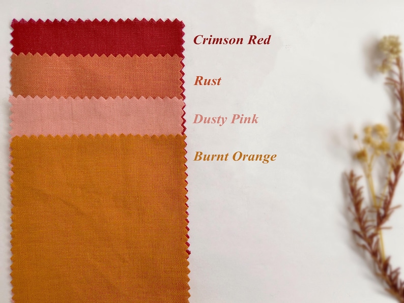 May include: Four rectangular fabric swatches with pinked edges arranged vertically. The colors are labeled as Crimson Red, Rust, Dusty Pink, and Burnt Orange. The fabric has a visible woven texture, and the text is printed next to each swatch.