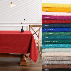 Puede incluir: Un mantel rojo con un sutil patrón texturizado, colocado sobre una mesa de madera con una silla en el fondo. La imagen muestra una variedad de colores, incluyendo amarillo, dorado, rosa, morado, rojo, azul marino, azul real, verde kelly, azul aguamarina, verde navideño, azul lago, verde menta, beige, marrón arroz, gris, marrón y negro.