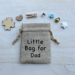 May include: A small hessian bag with a drawstring closure. The bag is decorated with the text "Little Bag for Dad".