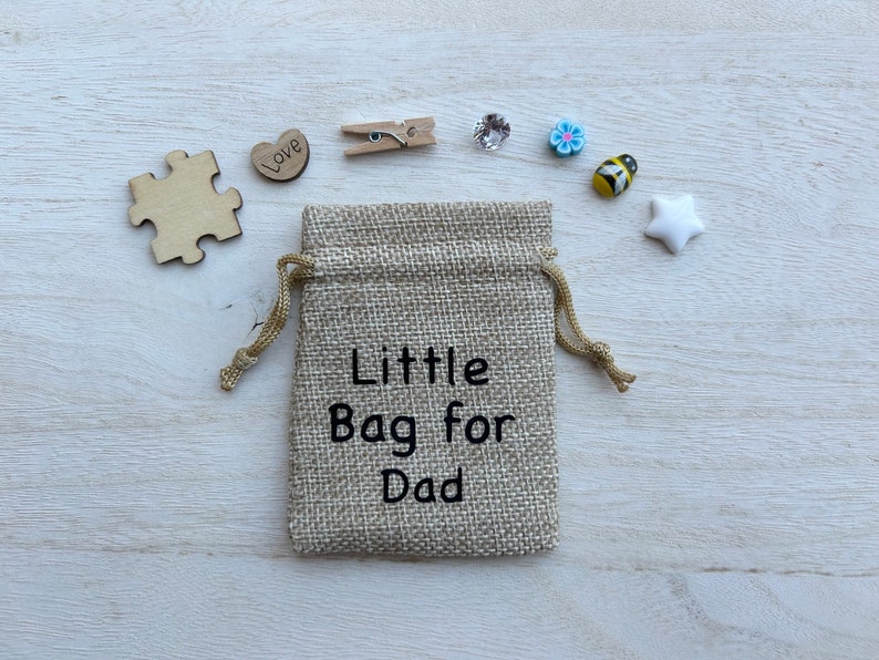 May include: A small hessian bag with a drawstring closure. The bag is decorated with the text "Little Bag for Dad".
