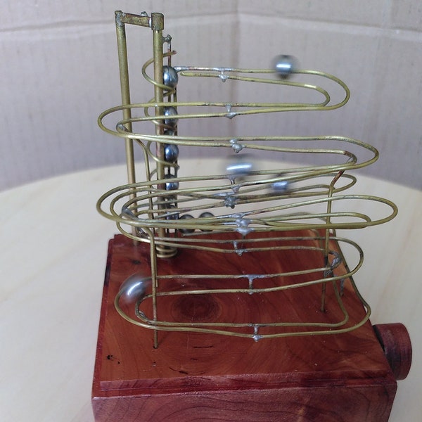 Marble Machine, rolling ball sculpture made of brass wire with steel balls and a larch wood base