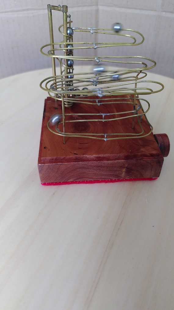 A handcrafted brass wire marble machine on a larch wood base — a mesmerizing kinetic art piece that looks like it belongs in a museum, with 228 favorites to prove it.