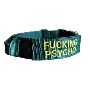 May include: A dark green dog collar with yellow embroidered text that reads "FUCKING PSYCHO".