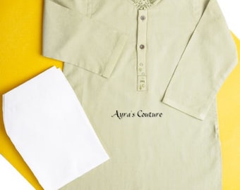 Puede incluir: Una camisa de manga larga de color verde claro con cuello blanco y bordados dorados. La camisa tiene cierre de botones y se combina con una gorra blanca.