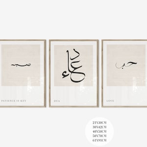 May include: Set of three framed prints with Arabic calligraphy and English text. The first print says "Patience is Key" and features the word "Sabr" in Arabic calligraphy. The second print says "Dua" and features the word "Dua" in Arabic calligraphy. The third print says "Love" and features the word "Hubb" in Arabic calligraphy. The prints are on a white background with a light beige border.
