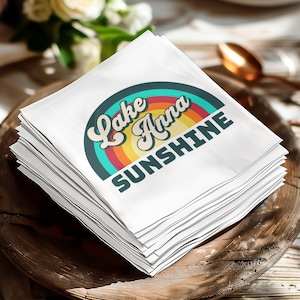 Stack of white napkins with "Lake Anna Sunshine" text and rainbow graphic.
