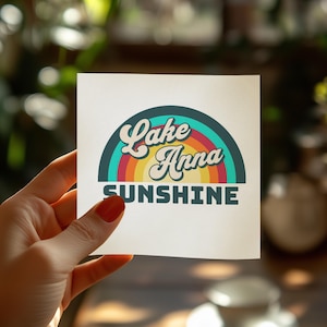 Lake Anna Sunshine text on a square sticker held by a hand.