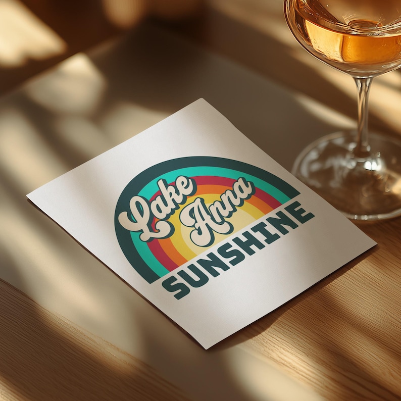 Lake Anna Sunshine rainbow graphic on a card with a glass of wine.