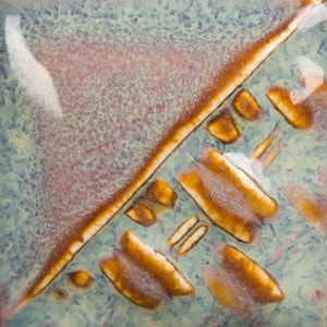 May include: Square ceramic tile with a textured surface. The tile features a diagonal brown line and several brown, oblong shapes against a mottled background of light blue and pink hues. The glaze has a glossy finish.