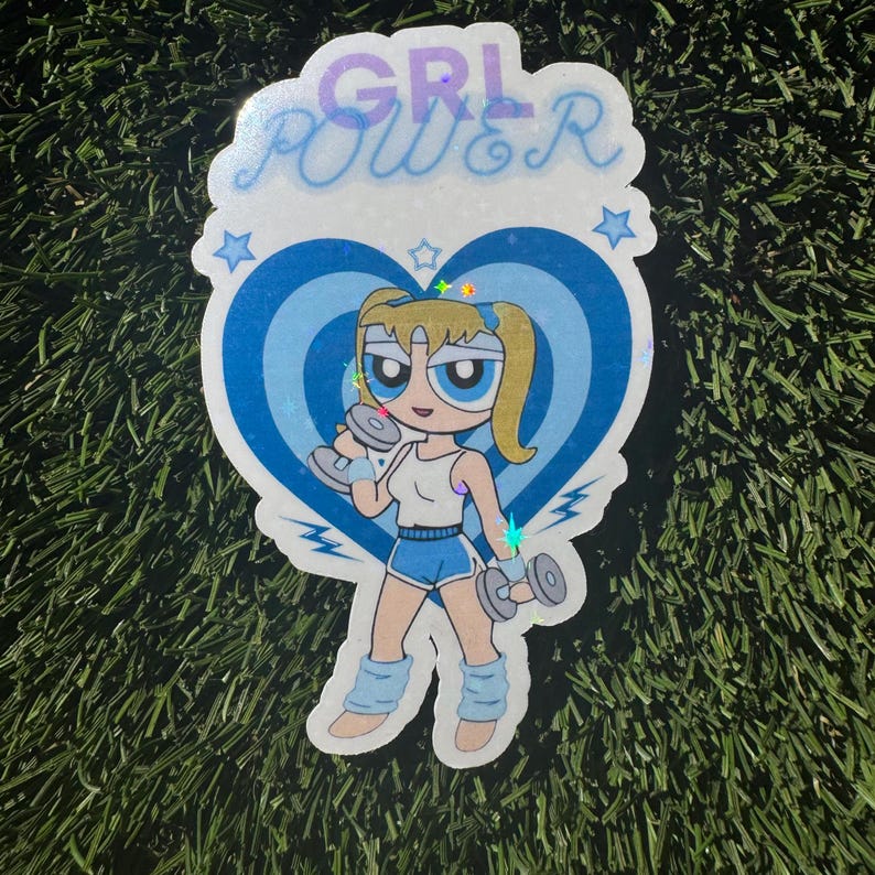 May include: A blue and white sticker with a cartoon character lifting weights. The character has blonde hair and blue eyes. The sticker says "GRL POWER" in a glittery font.