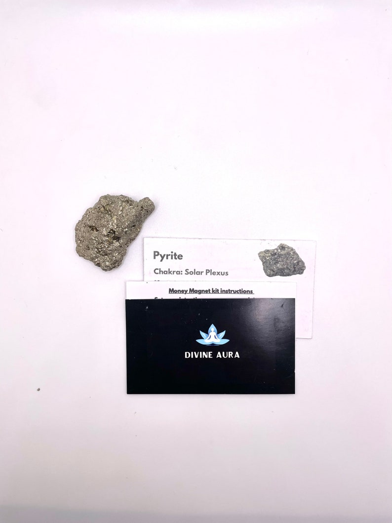 May include: A small, rough, gray and silver pyrite crystal with a white card that reads "Pyrite Chakra: Solar Plexus Money Magnet kit instructions. DIVINE AURA".
