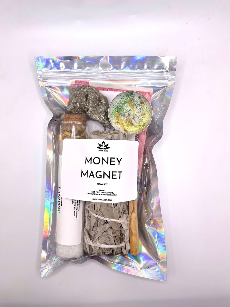 May include: A clear plastic bag containing a money magnet ritual kit. The kit includes sage, palo santo, pyrite, and a spiritual bath intention candle. The bag has the text "MONEY MAGNET RITUAL KIT" printed on it.