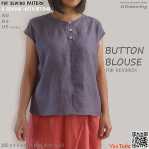 May include: A button-down blouse in a muted purple hue, featuring a round neckline and short sleeves. The blouse is worn with a coral-coloured skirt. The image includes text that reads "BUTTON BLOUSE FOR BEGINNER" and "PDF SEWING PATTERN & SEWING INSTRUCTIONS".