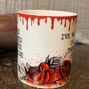May include: White ceramic mug with red dripping paint around the rim. The mug has a black and white illustration of roses and leaves with red splatter paint. The text "I've waited for this moment my entire life" is printed on the mug.