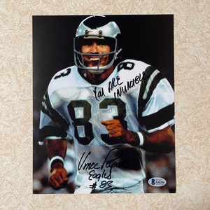 May include: A signed photograph of a football player wearing a green and white jersey with the number 83. The player is holding a football and running. The signature reads "You are INNUMERABLE" and "Vince Papale Eagles #83".