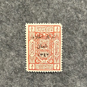 May include: A red and white stamp with Arabic script and a central design featuring a building with a dome. The stamp is surrounded by a decorative border.