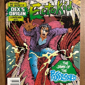 May include: Comic book cover featuring a green and black title "Ectokid" with the text "Super Heroes from the Mind of Clive Barker" above it. The cover art shows a man in a purple jacket and blue jeans falling into the open jaws of a monstrous creature.