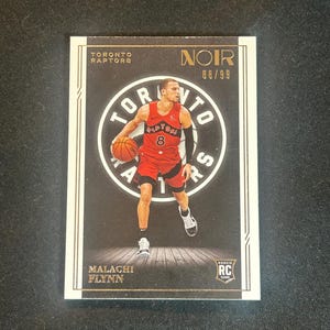Puede incluir: Una tarjeta de intercambio de baloncesto con Malachi Flynn, un jugador de los Toronto Raptors. La tarjeta es negra y dorada con una foto de Flynn driblando el balón. El número de la tarjeta es 68/99 y la tarjeta está etiquetada como "Noir".