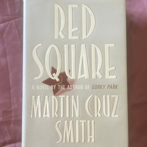 May include: A white book cover with the title "Red Square" in bold white letters. The book is by Martin Cruz Smith and is a novel by the author of "Gorky Park".